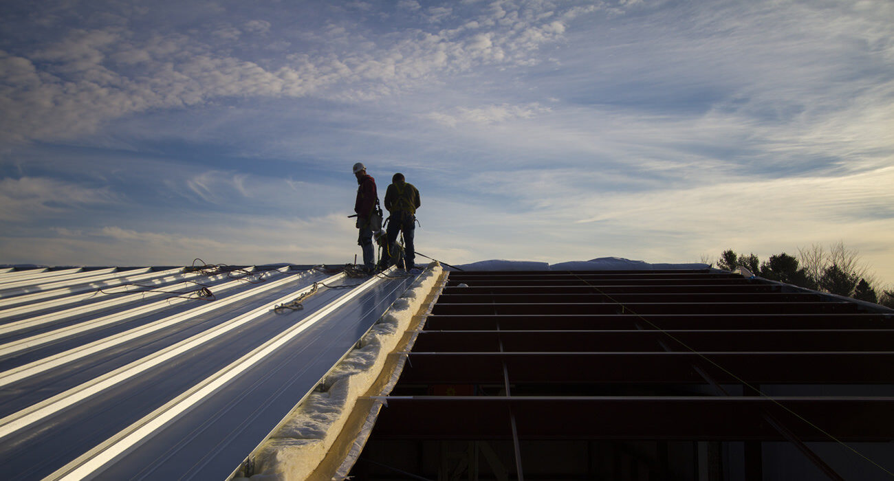 Two men working on a roog.